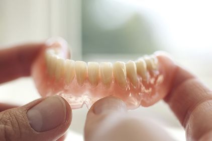 Image of dentures being held up to light