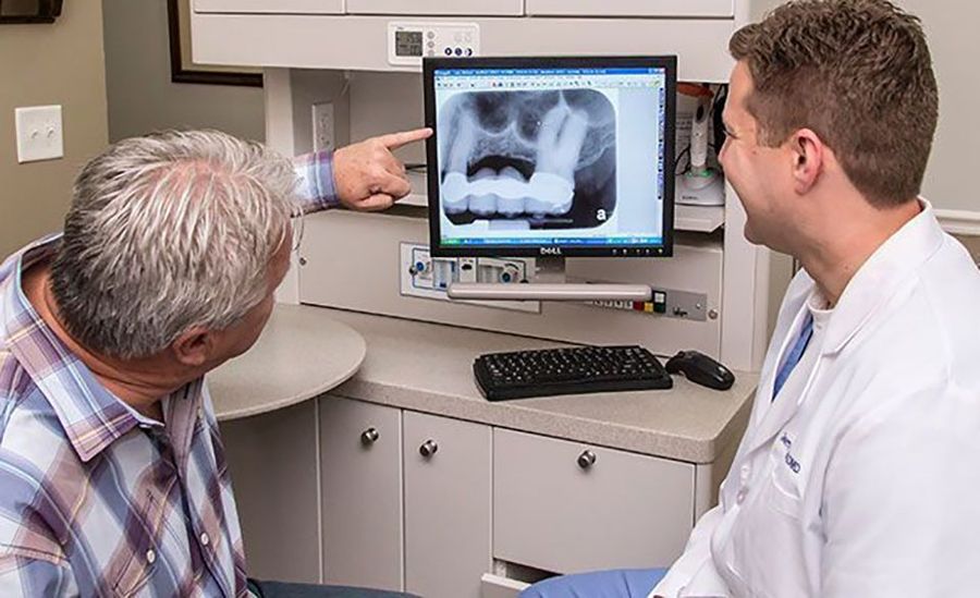 Dr. Hancock reviewing a digital x-ray with a patient